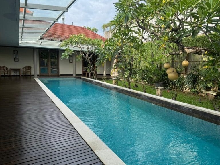 Kolam renang pribadi dan taman asri di dalam rumah mewah Teras Ayung Residence dekat Living World Mall Bali.