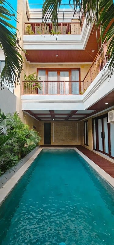 Area ruang makan eksklusif yang menyatu dengan dapur dan pemandangan ke arah kolam renang.