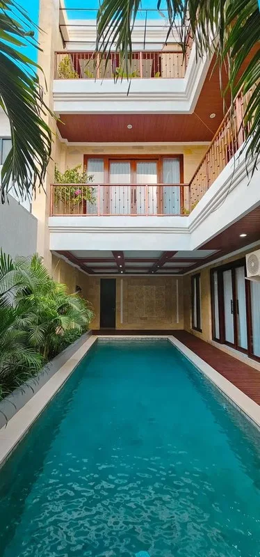 Area ruang makan eksklusif yang menyatu dengan dapur dan pemandangan ke arah kolam renang.