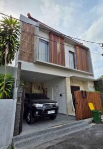 Fasad villa modern di Ungasan Bali dengan dinding batu alam dan garasi minimalis siap huni.