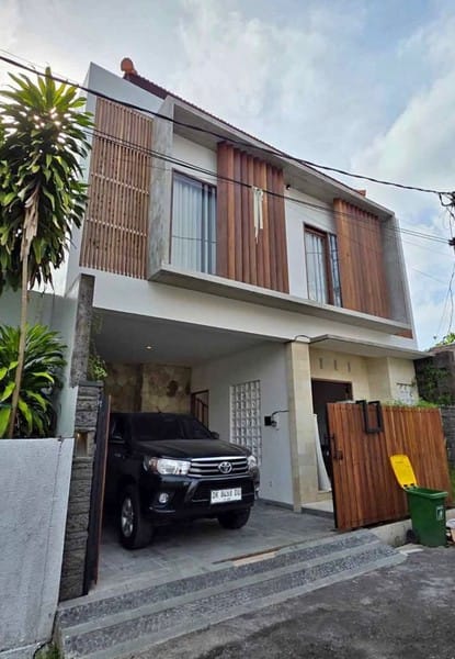 Fasad villa modern di Ungasan Bali dengan dinding batu alam dan garasi minimalis siap huni.