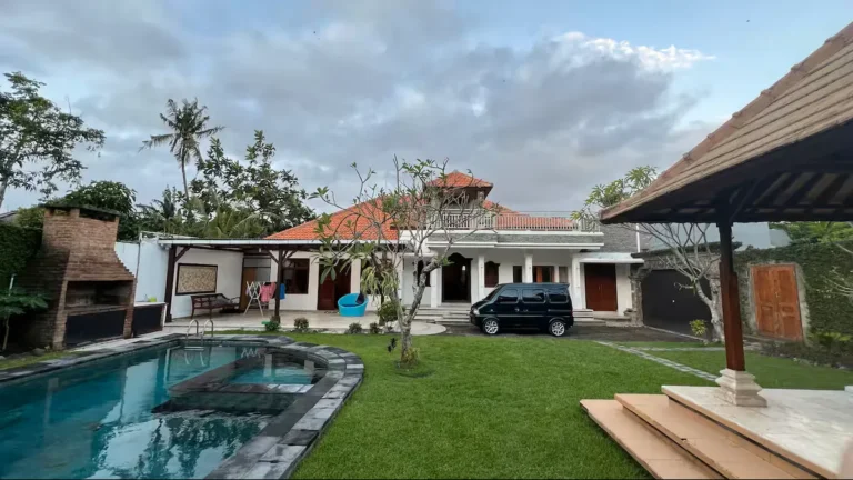 Kamar tidur utama yang nyaman dan luas di villa dekat Canggu. Dilengkapi furnitur berkualitas, pendingin ruangan, dan akses pintu kaca besar menuju taman pribadi.