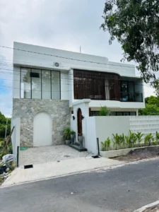 Eksterior villa dijual di ungasan dengan gaya modern mediteranian tropical dan aksen kayu minimalis.